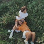 Zwei Freundinnen liegen lachend im Gras