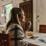 Frau riecht an heißer Tasse