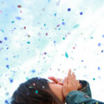 Frau wirft Konfetti in die Luft