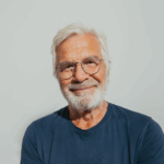 Portrait eines älteren Mannes mit grauen Haaren im blauen Oberteil